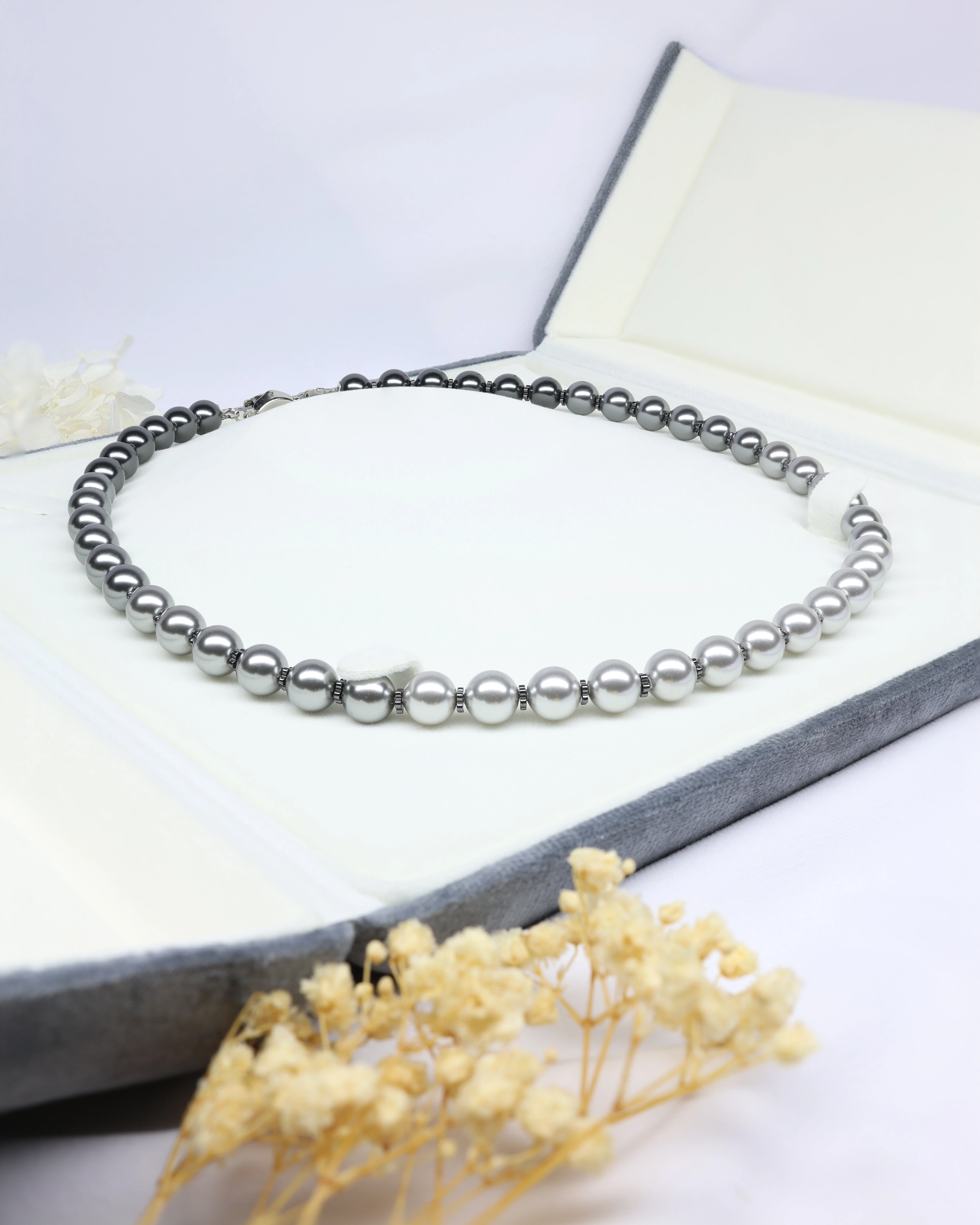 Black gradient Pearl necklace in a luxury case with a blurred background