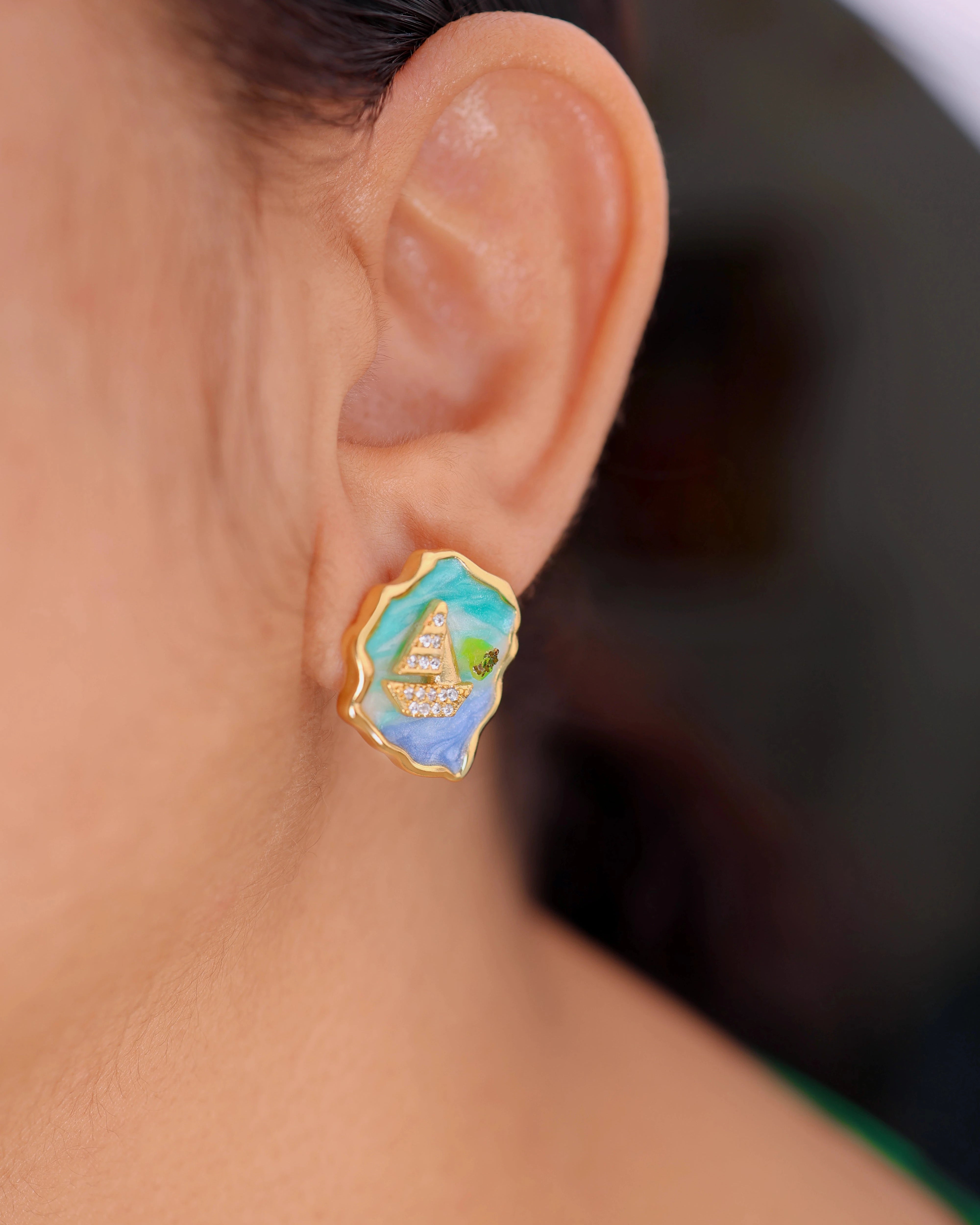 Close-up of an ear wearing a colorful earring with a pyramid design.