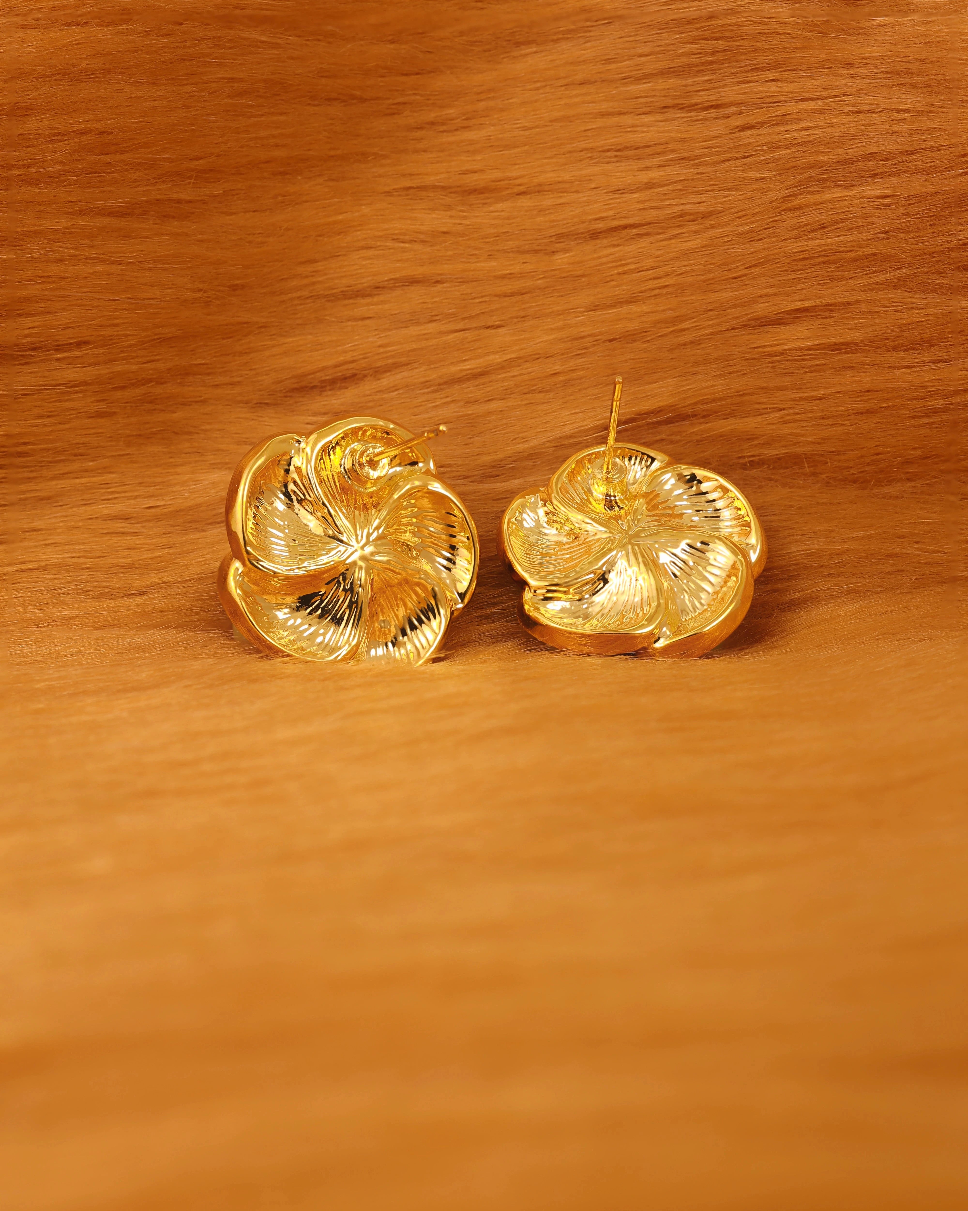 Pair of gold earrings on golden fur