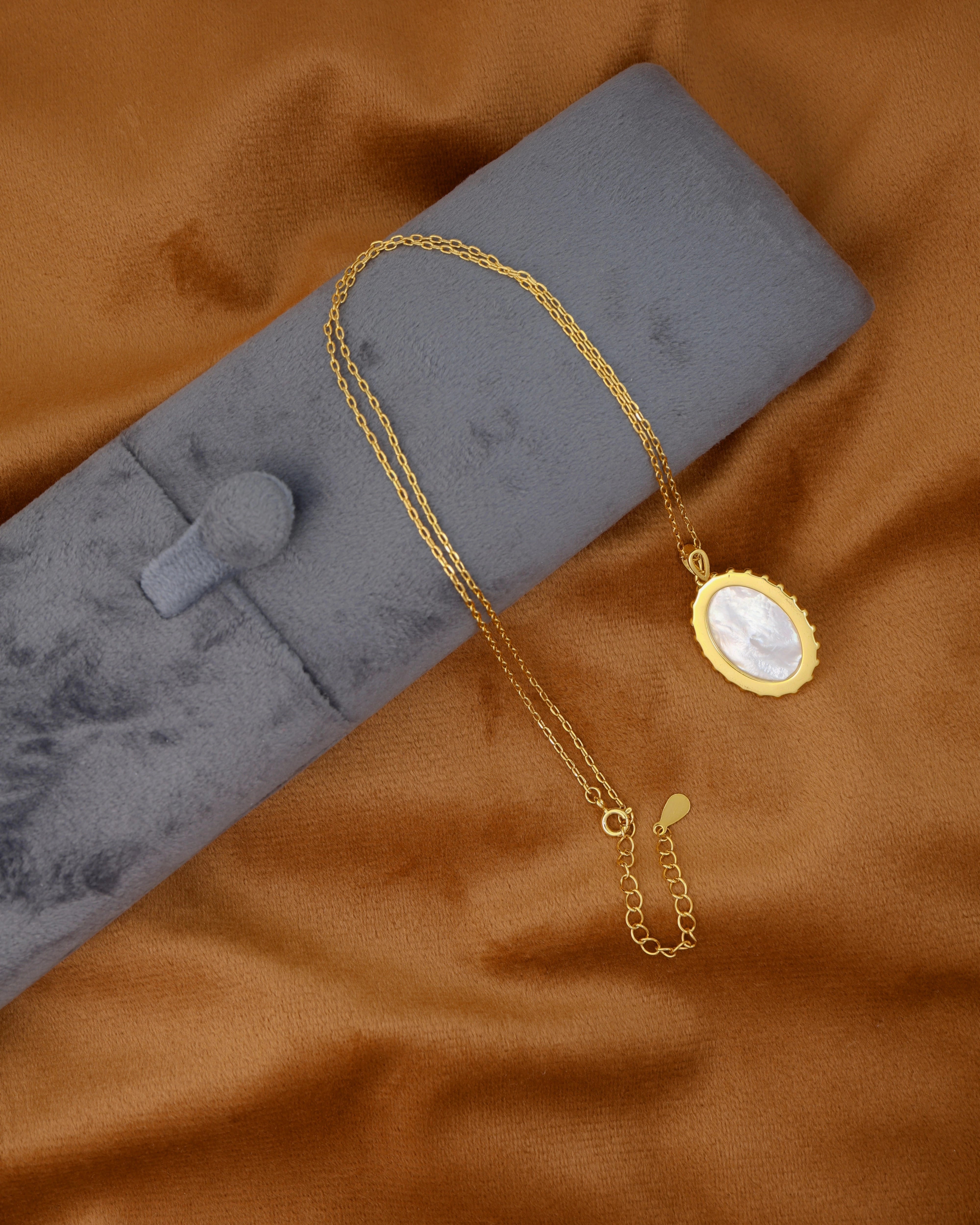Mother of Pearl pendant necklace on a golden fabric background