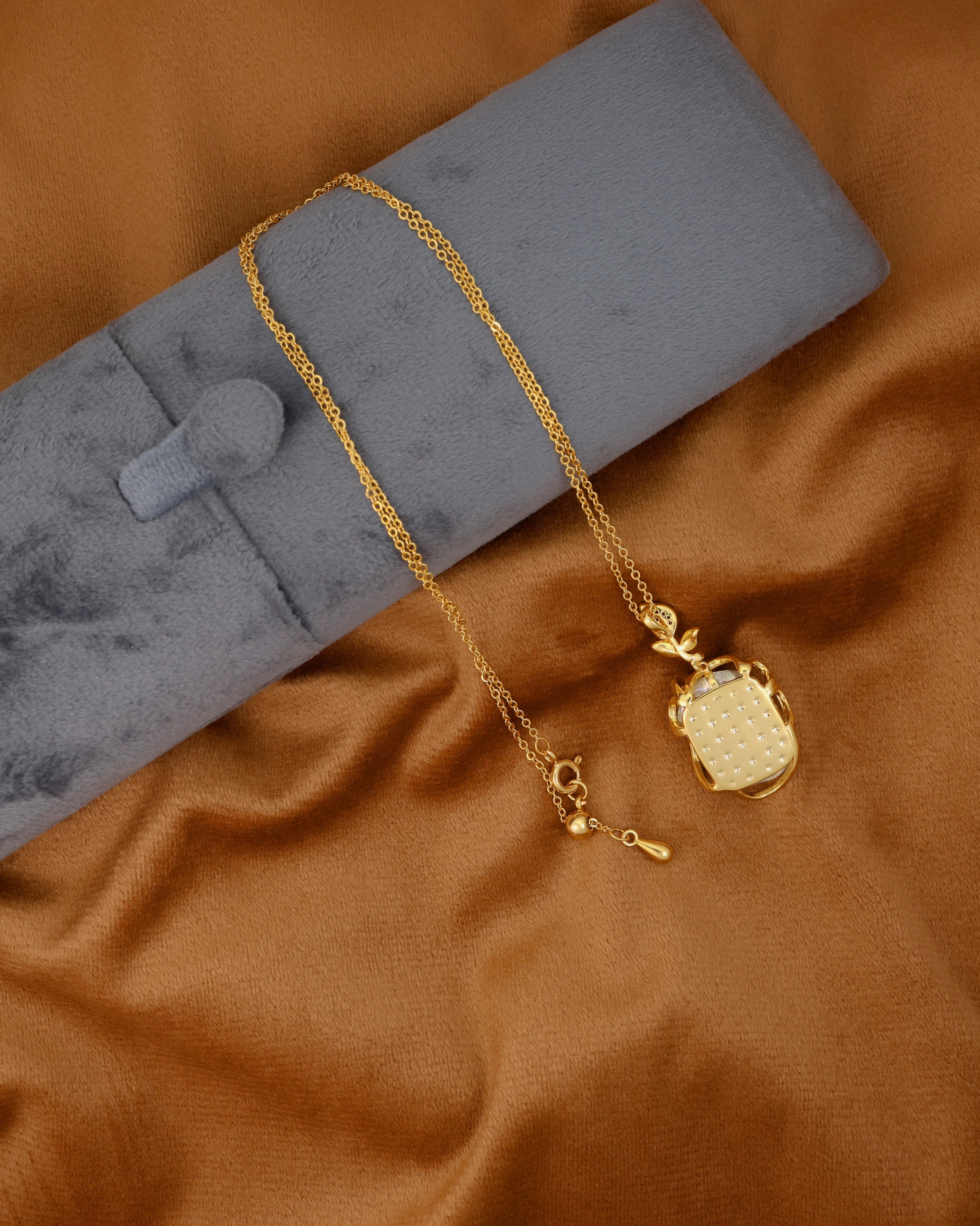 Gold necklace with a pendant on a brown fabric background