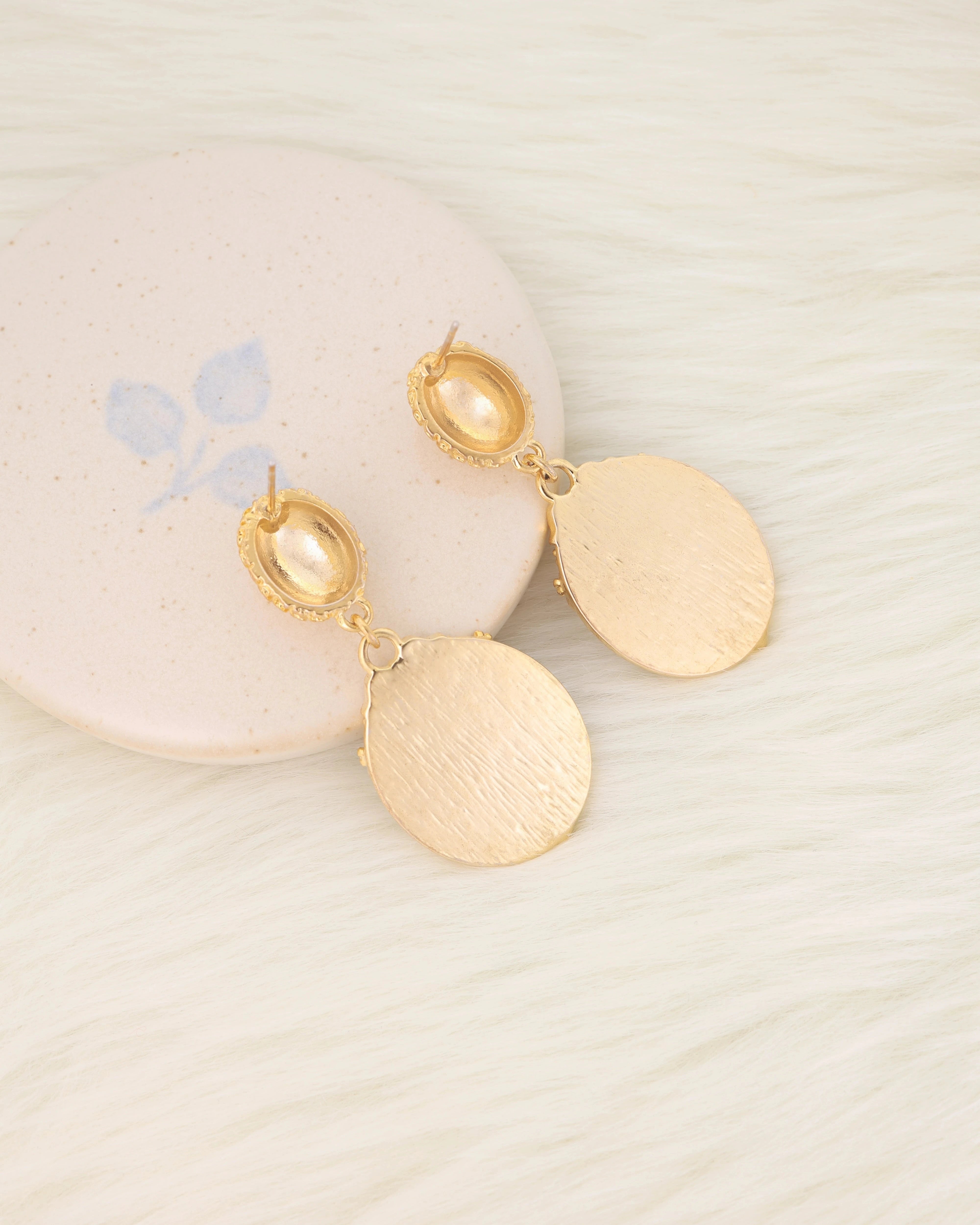 Gold platted earrings on a light background