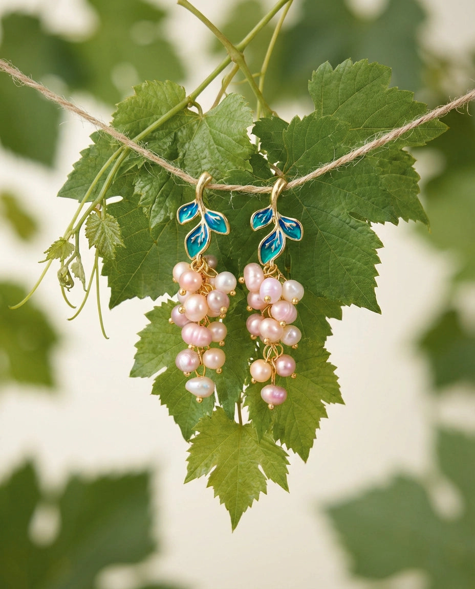 Pearl earrings hanging on a vine with green leaves