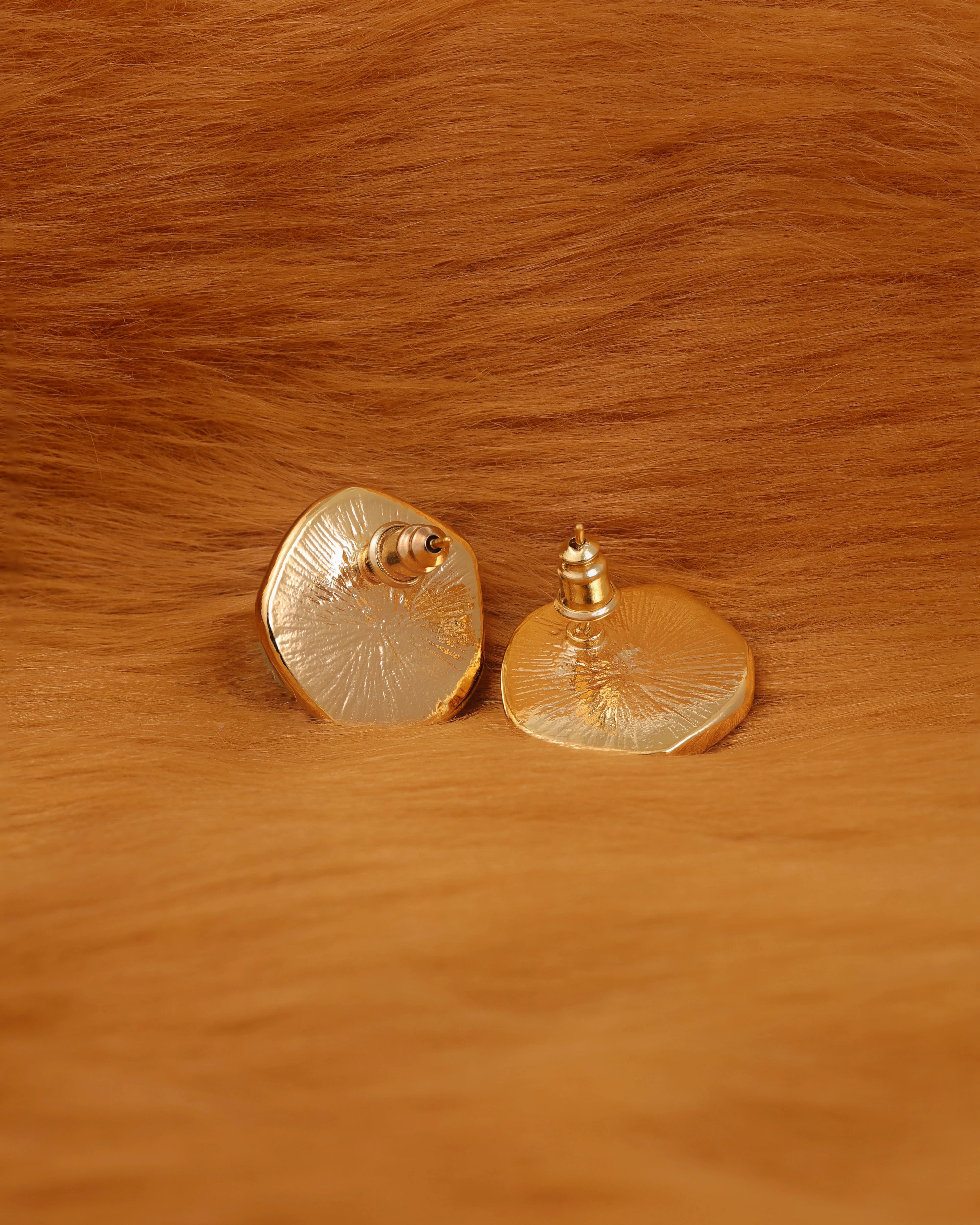 Gold earrings on a fur surface