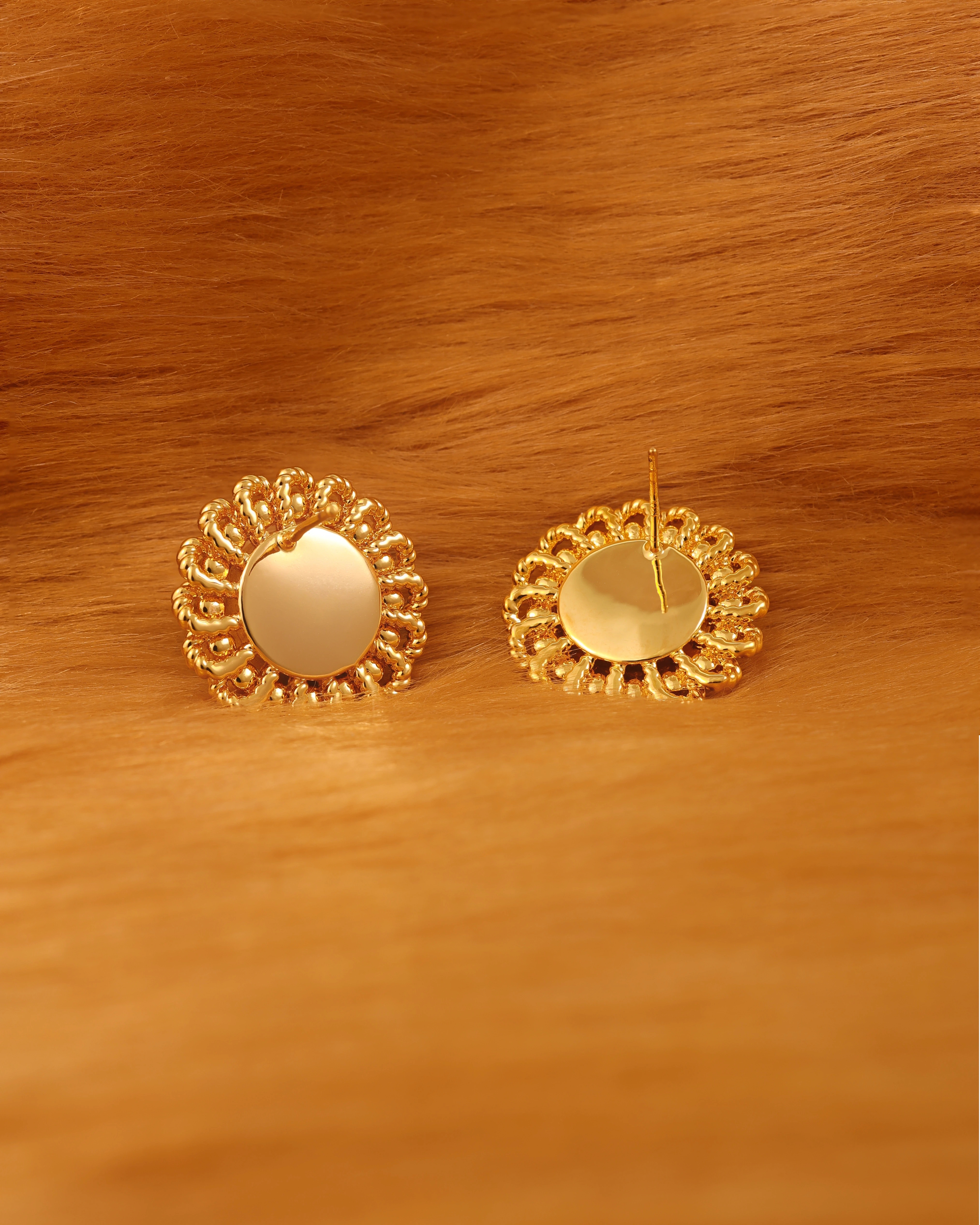 Gold earrings with a circular design on golden fur